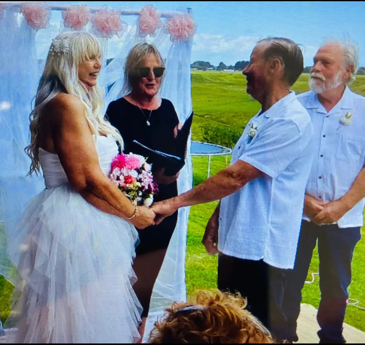 Couple exchanging vows with Pauline at an outdoor ceremony